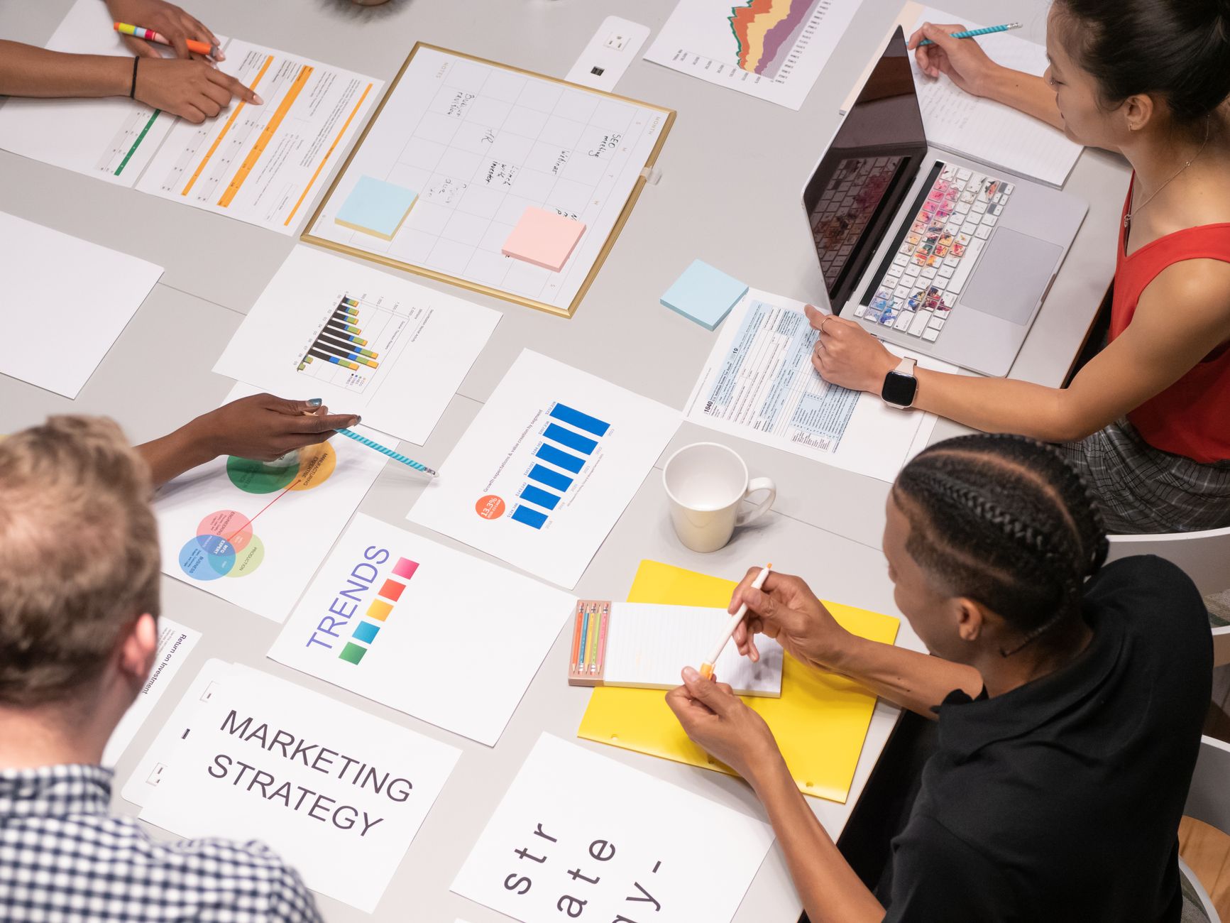 Overhead shot of diverse team analyzing marketing strategies with charts and graphs. — Deciding on the Most Effective SEO Out