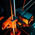 A colorful close-up of a 3D printer operating, showcasing mechanical precision and technology. — Do Not Establish and Neglect