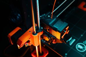A colorful close-up of a 3D printer operating, showcasing mechanical precision and technology. — Do Not Establish and Neglect