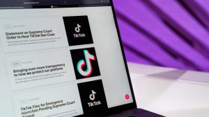 Close-up of laptop screen showing TikTok news articles with a purple background. — Enhance Your Influence: The Strategic Adva