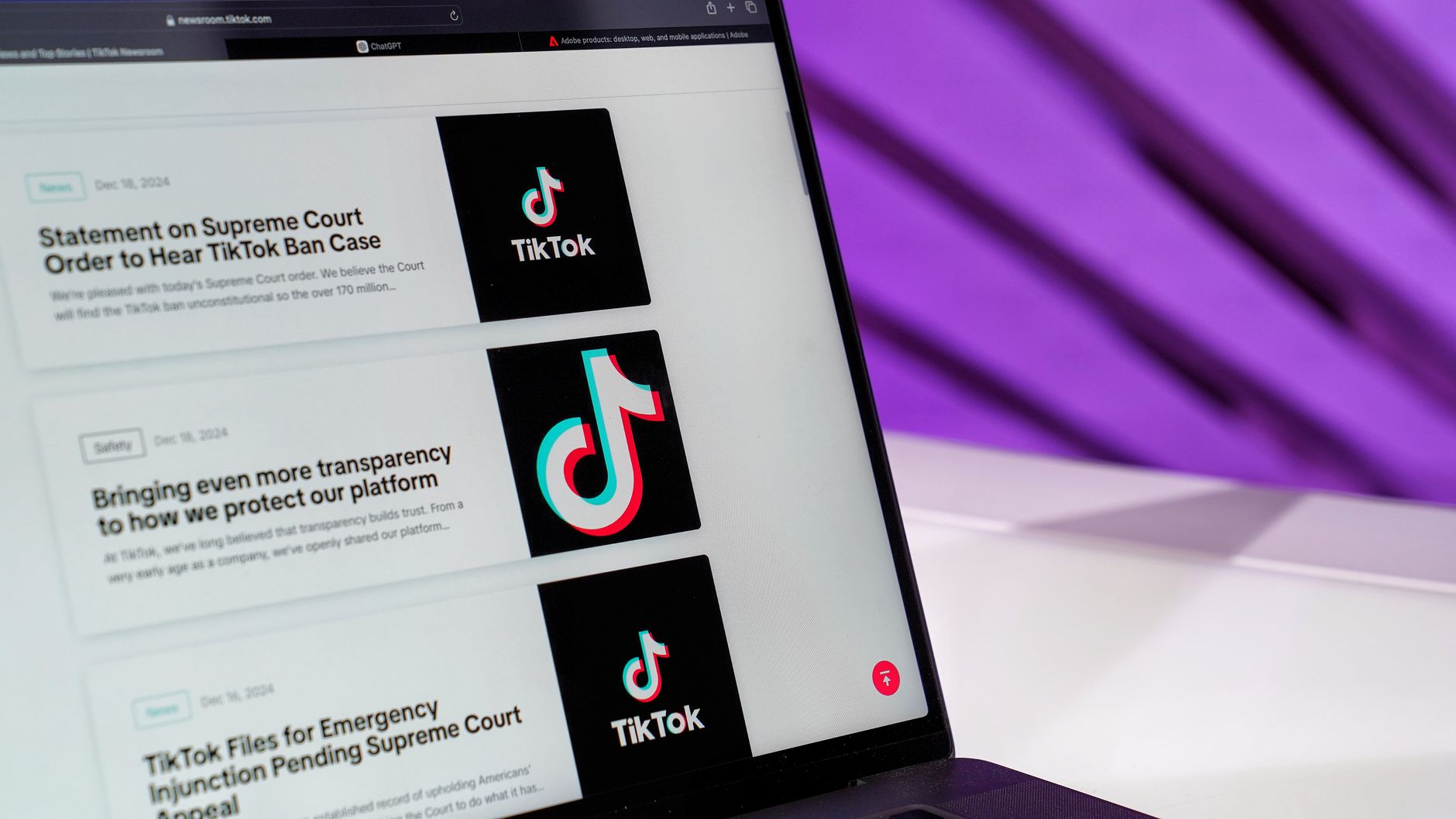 Close-up of laptop screen showing TikTok news articles with a purple background. — Enhance Your Influence: The Strategic Adva