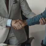 Image of a professional handshake between two businessmen in an office setting. — Exploring the Benefits and Challenges of CF