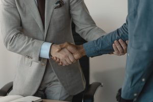 Image of a professional handshake between two businessmen in an office setting. — Exploring the Benefits and Challenges of CF