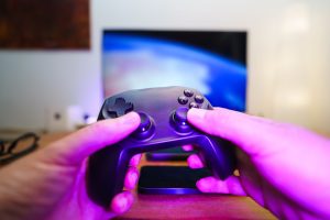 Close-up of hands holding a game controller in front of a TV screen. Perfect for entertainment setups. — Lao Lottery Websites