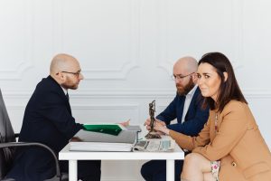 A lawyer consulting a couple in an elegant office setting, focusing on legal matters. — Local Patent Attorneys to Help Secure