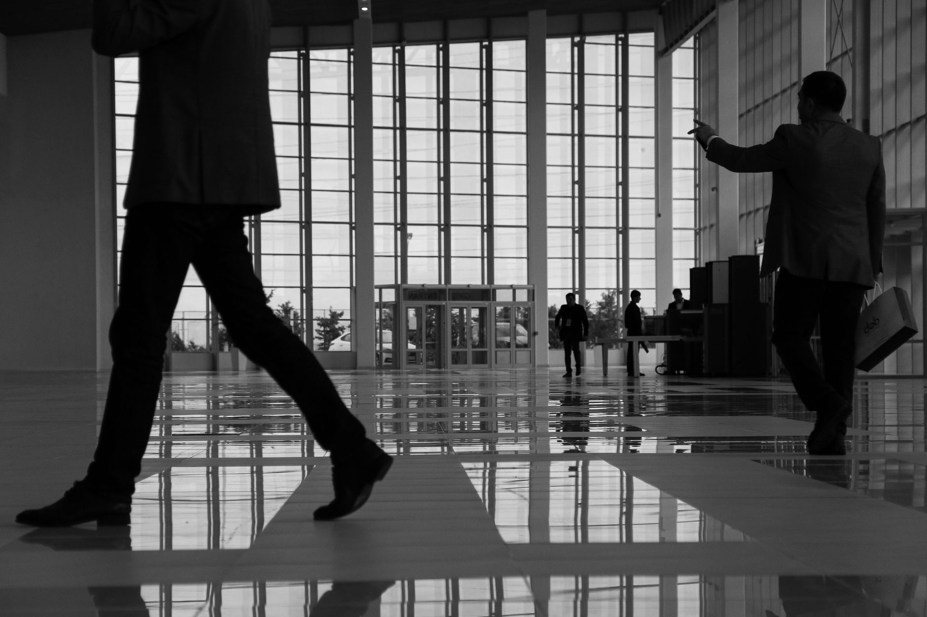 Business professionals walk through a modern, glass-paneled indoor space. — Navigating the World of Online Testosterone Presc