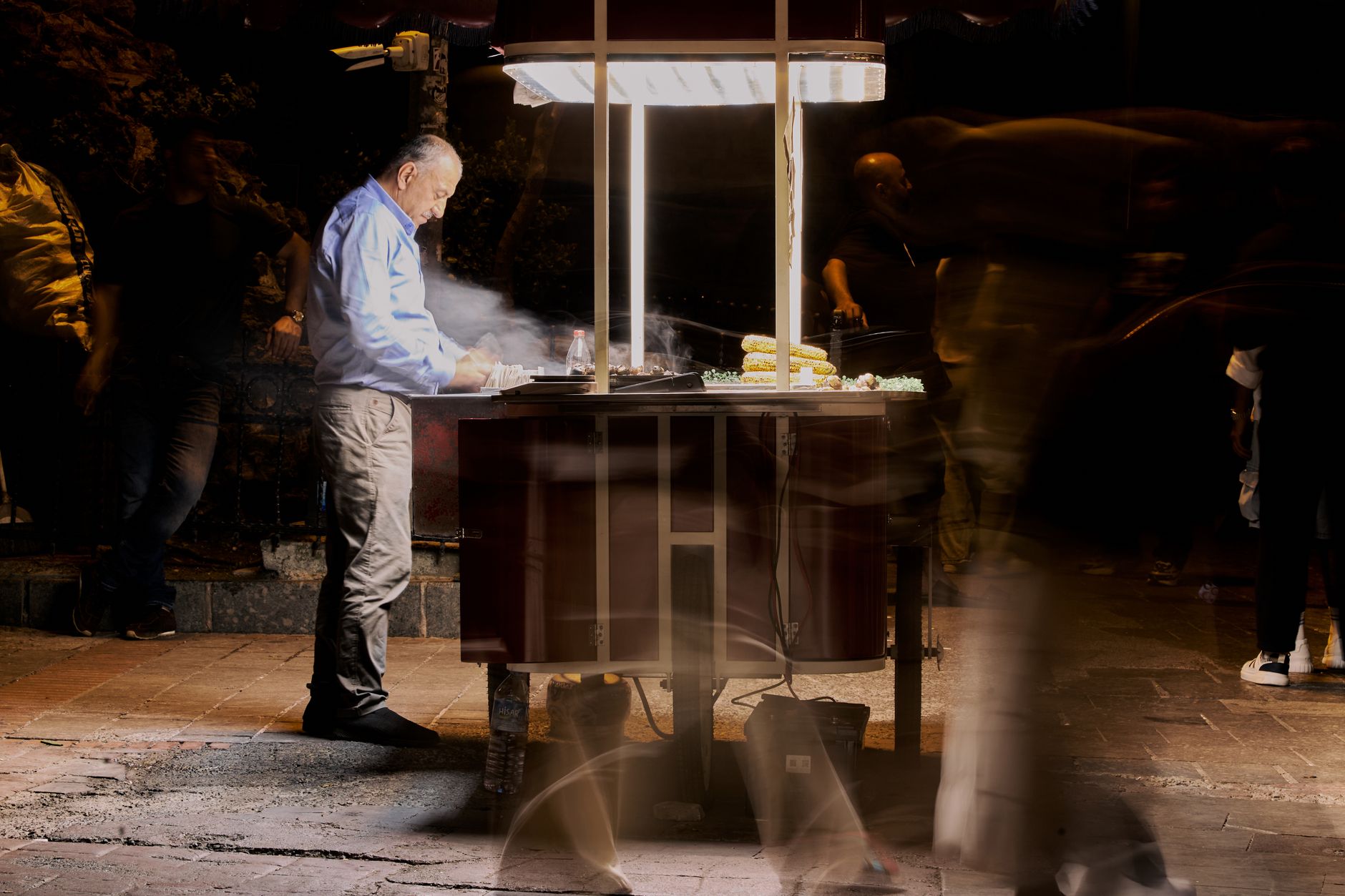 Street vendor cooking food at night with blurred people passing by. — NFLbite: Unrivalled Reddit NFL Streaming Platform