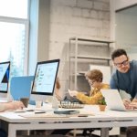 Team of professionals discussing project ideas in a modern office setting, fostering communication and teamwork. — Optimize Y
