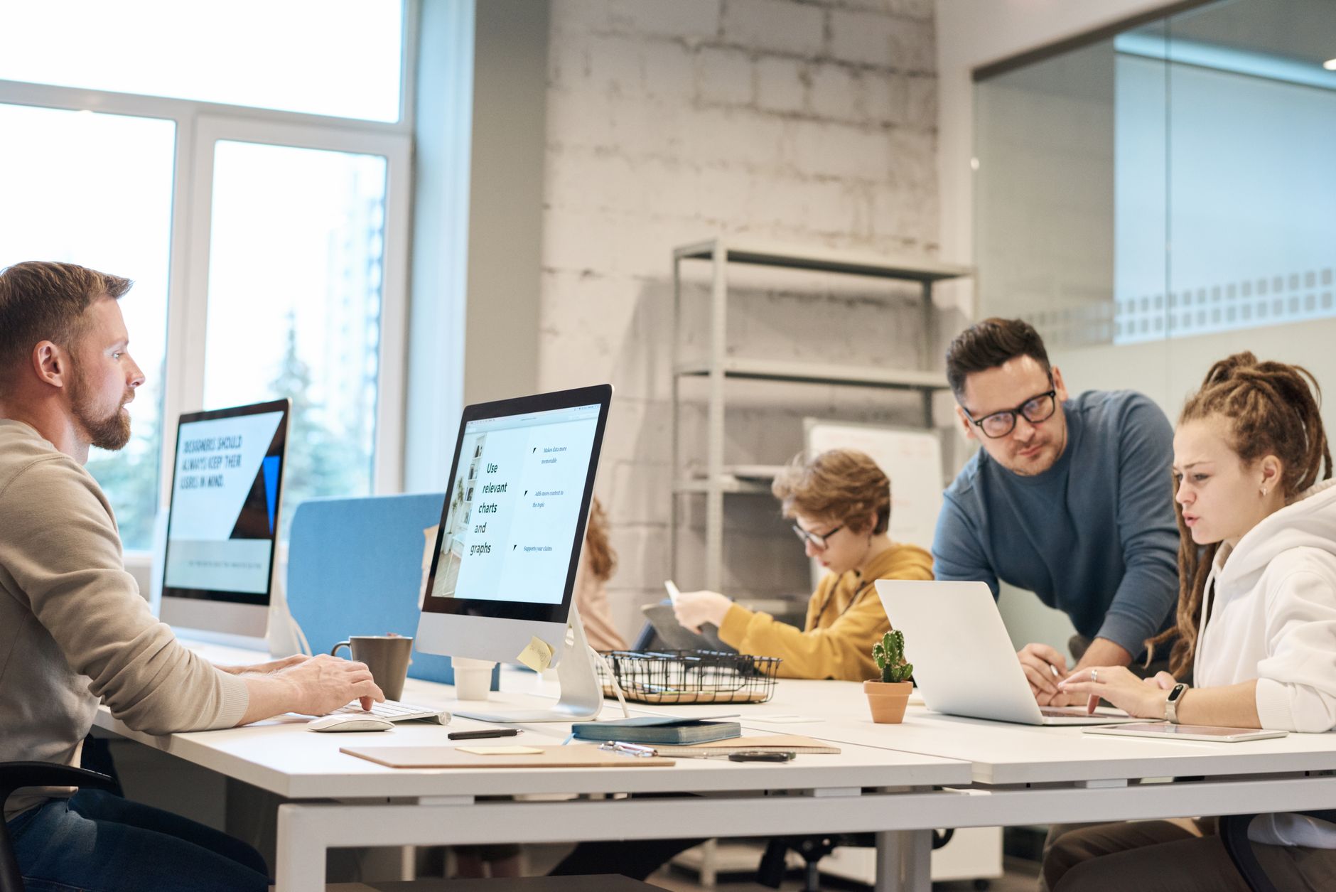 Team of professionals discussing project ideas in a modern office setting, fostering communication and teamwork. — Optimize Y