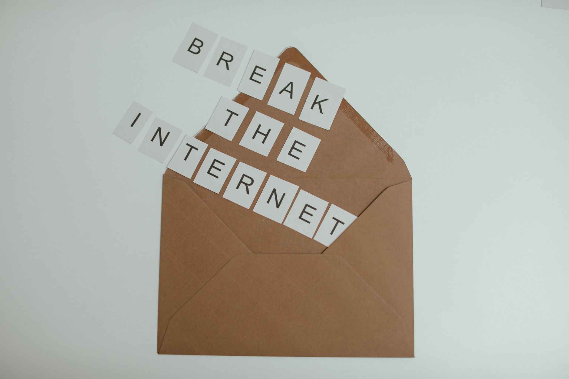 Brown envelope with tiles spelling 'Break the Internet' creates a conceptual and modern theme. — Remote Living Doesn't Mean G