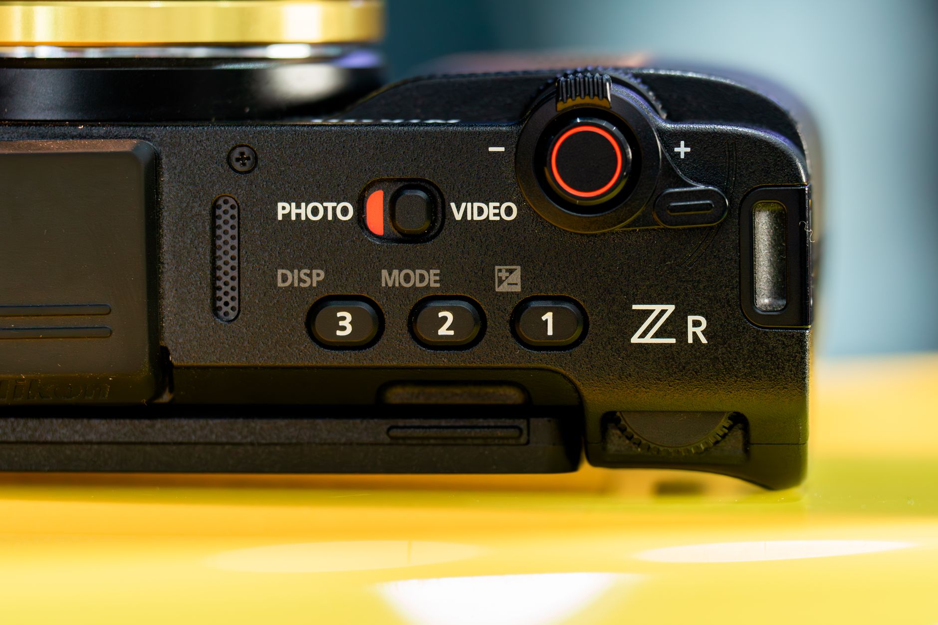 Detailed close-up of a camera's control interface featuring buttons and dials, emphasizing its design and functionality. — SM