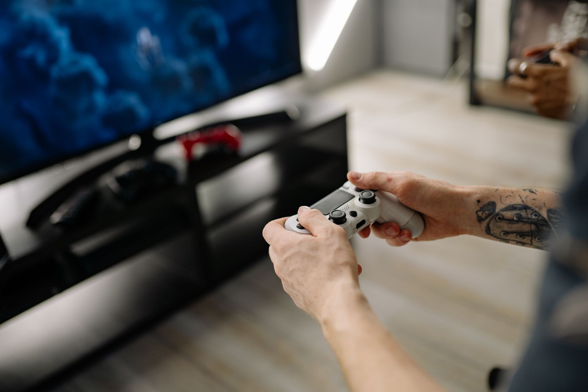 Person playing video games using a game controller indoors on a modern TV setup. — Beat the Best in Pokdeng Online wi