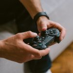 Hands holding a game controller while playing video games indoors, a leisure activity. — Get Maximum Fun Out of Your