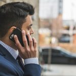 Professional man in suit making a phone call outside in city setting. — TEFL in Peru: Breaking Language Barriers