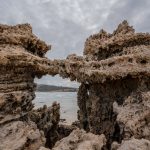A striking coastal rock formation displaying natural erosion against a cloudy backdrop by the sea. — The Benefits of Using Ma