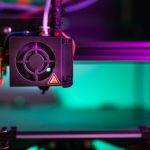 Vibrant close-up of a 3D printer component in action with colorful lighting creating a modern industrial vibe. — The Future o