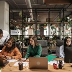 Multiethnic call center team collaborating and discussing reports in a modern office. — The Future of Bitcoin Price: Bullish