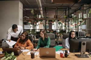 Multiethnic call center team collaborating and discussing reports in a modern office. — The Future of Bitcoin Price: Bullish