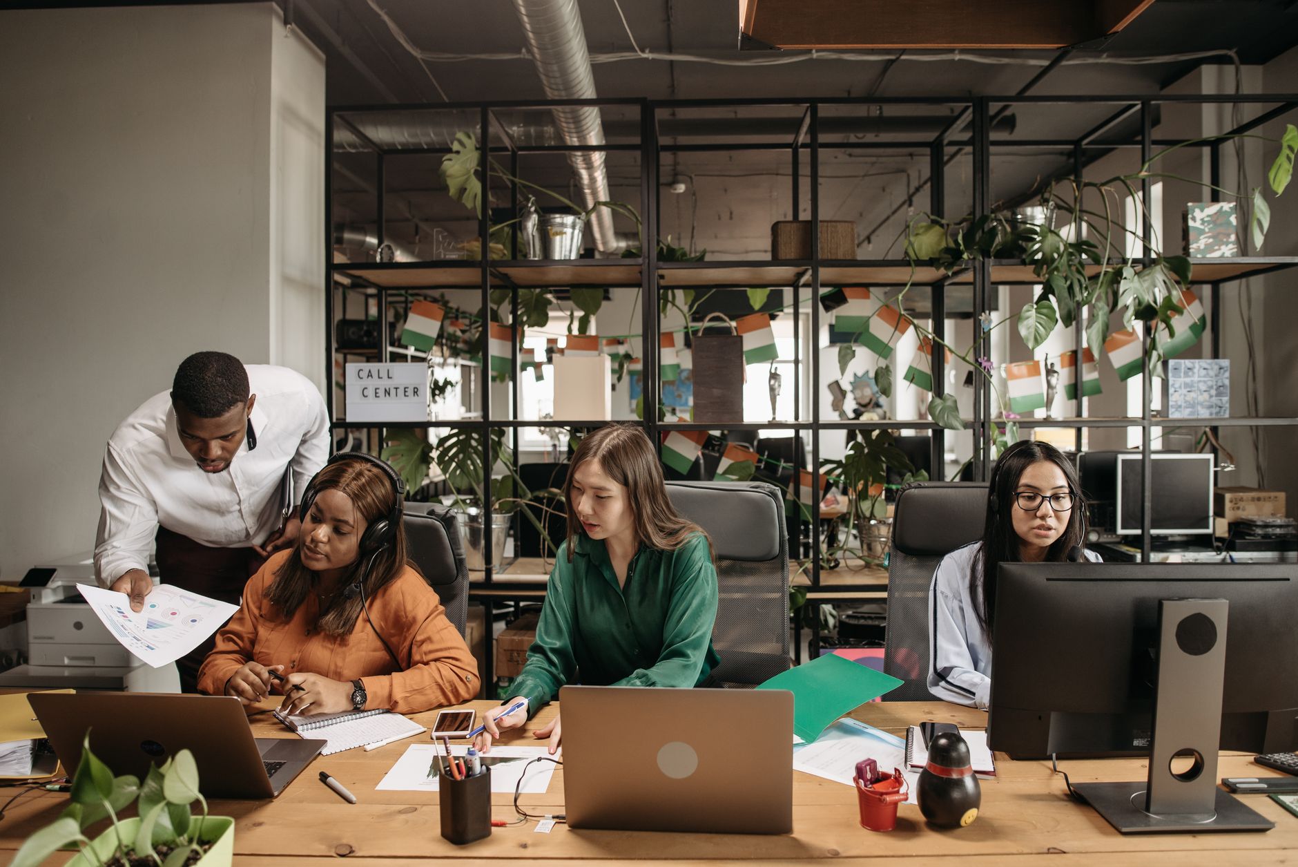 Multiethnic call center team collaborating and discussing reports in a modern office. — The Future of Bitcoin Price: Bullish