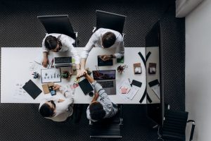 High angle view of colleagues collaborating around a conference table in a modern office setting. — The Future of Marketing: