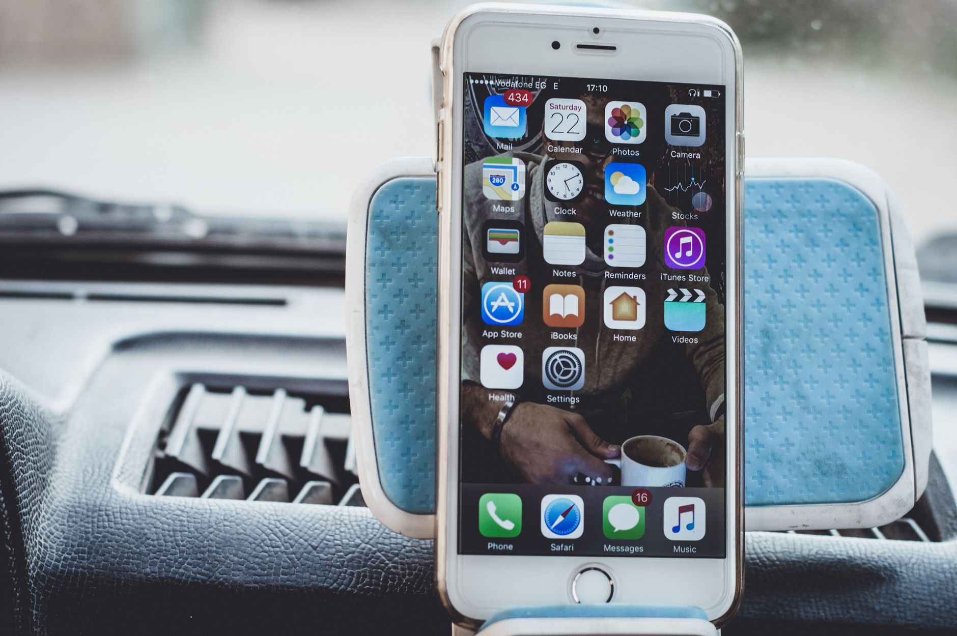 Close-up of a smartphone mounted on a car dashboard showing home screen with apps. — The Promise of Technology is Intangible