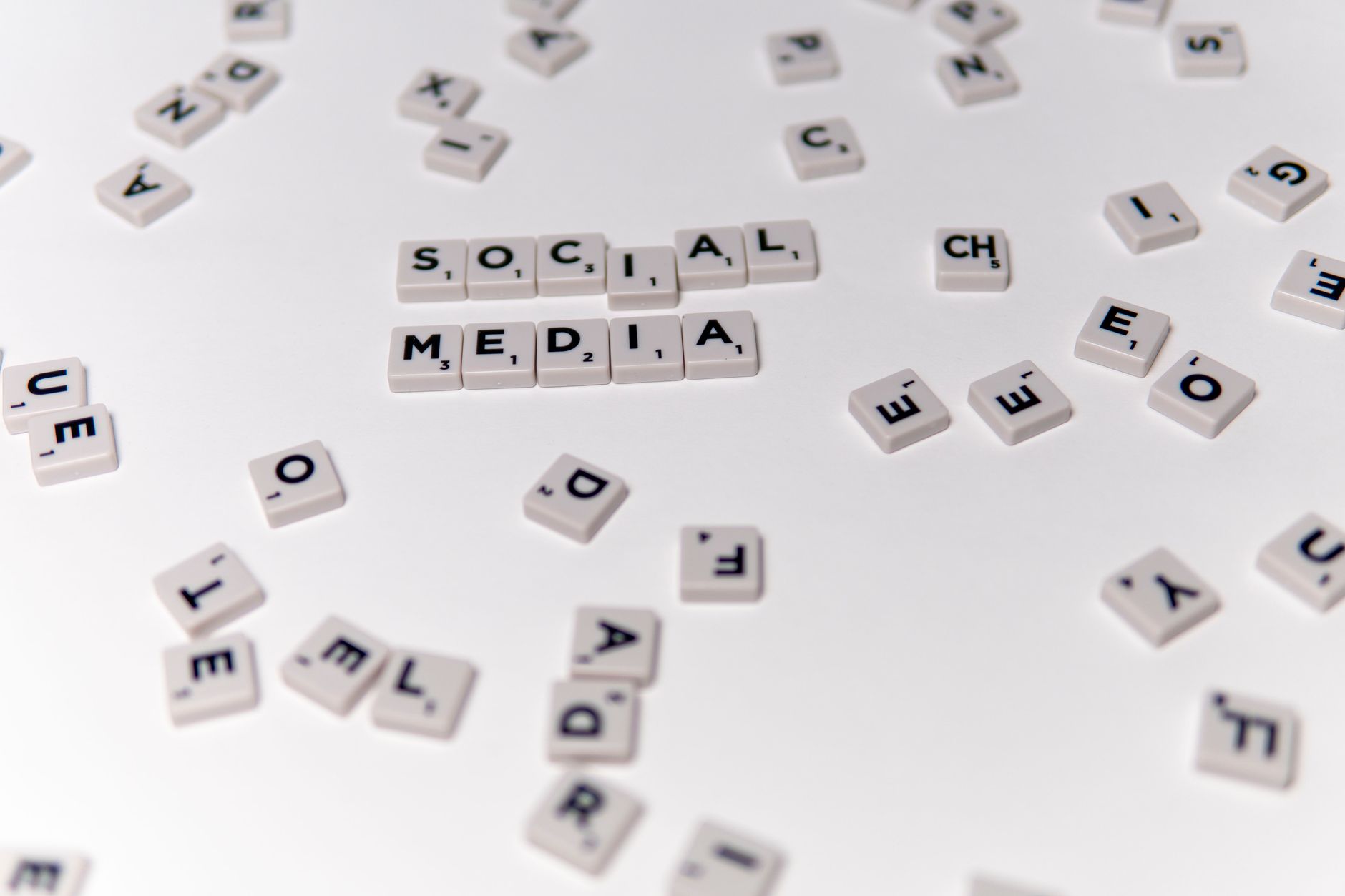 White Scrabble tiles forming the phrase 'social media' on a scattered background. — The Pros and Cons of Viewing Instagram St