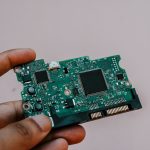 Close-up image of a hand holding a circuit board from a hard drive, showcasing electronic technology. — Top 10 Mistakes Busin