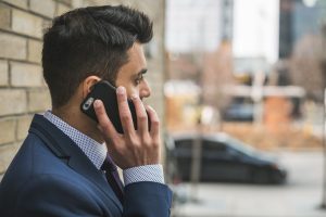 Professional man in suit making a phone call outside in city setting. — Using MetaTrader 4 on Android for Market Monitoring a