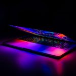 A partially closed MacBook with vibrant, colorful light reflections on a dark background. — What To Know About The Fibonacci
