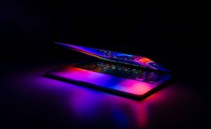 A partially closed MacBook with vibrant, colorful light reflections on a dark background. — What To Know About The Fibonacci