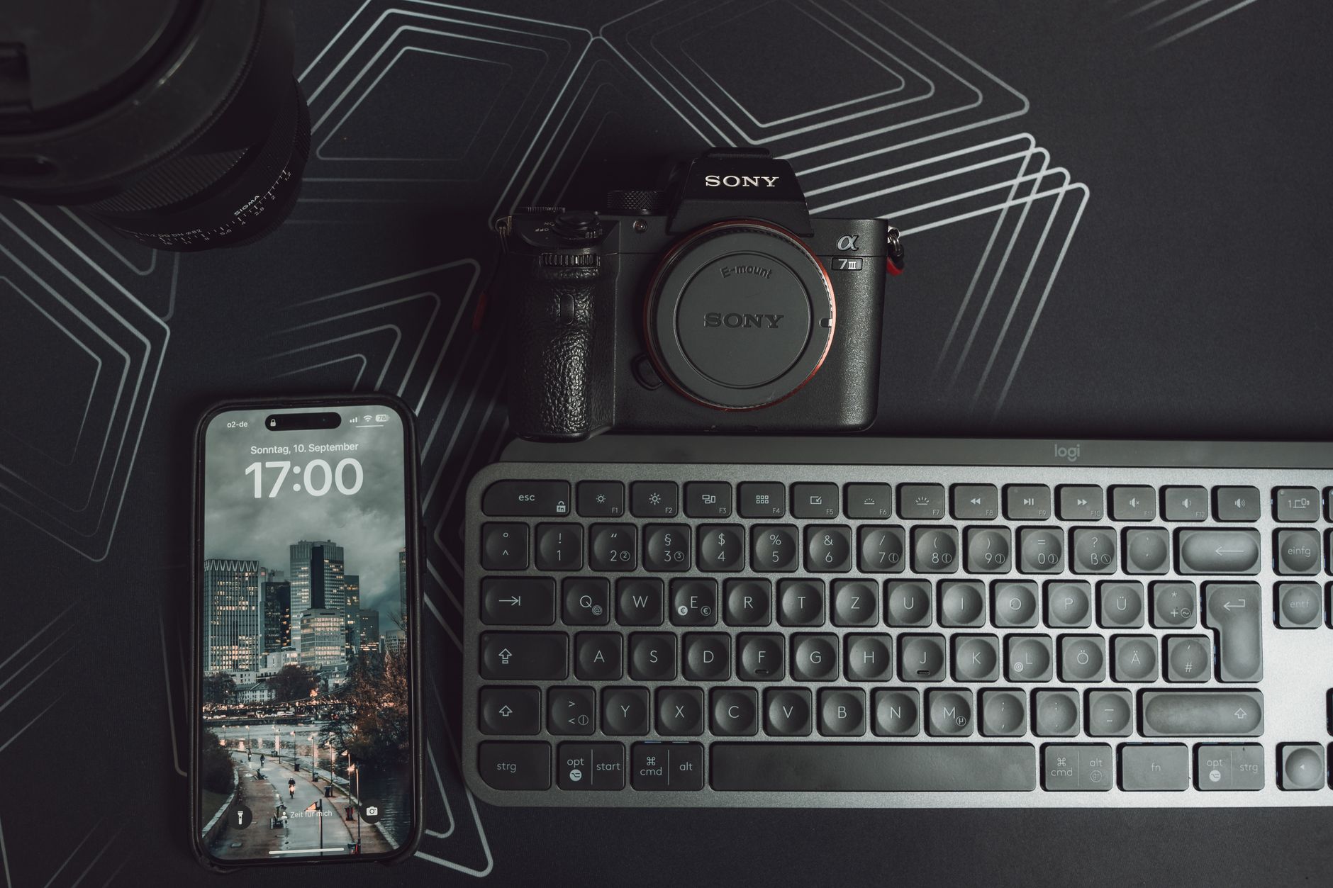 Elegant workspace setup featuring camera, smartphone, and keyboard on a geometric background. — Wholesale Electronics - Endle