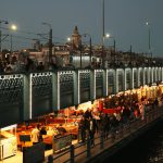 Night view of Galata Bridge bustling with people and distant Galata Tower in Istanbul. — Why Boxing in Pipes is a Homeowner's